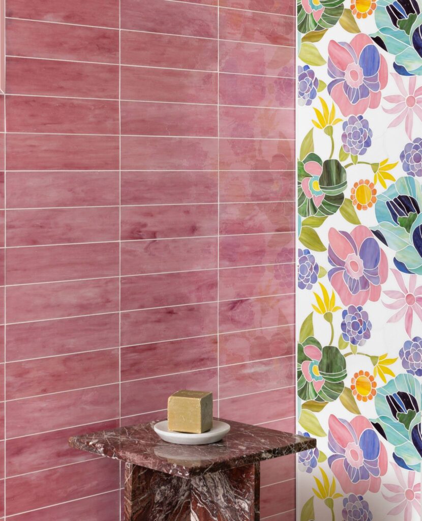 Modern bathroom featuring rose-toned glass tiles and botanical mosaic